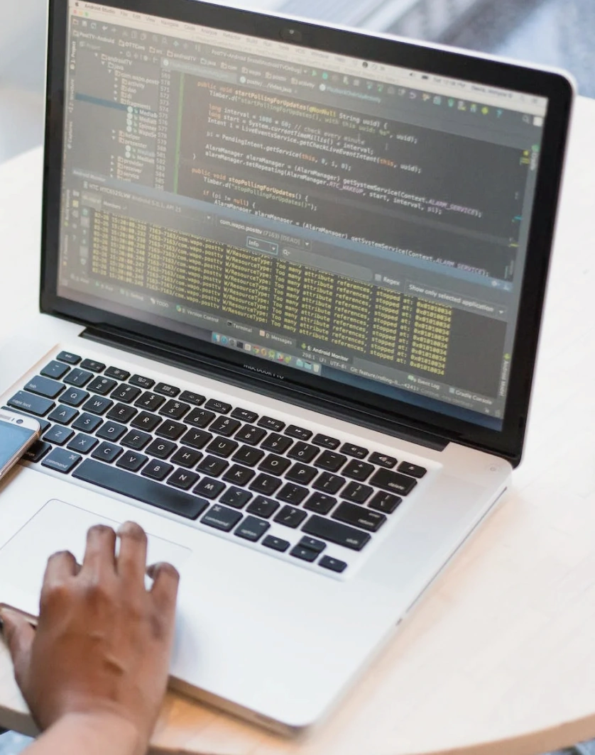 a person sitting at a table using a laptop computer