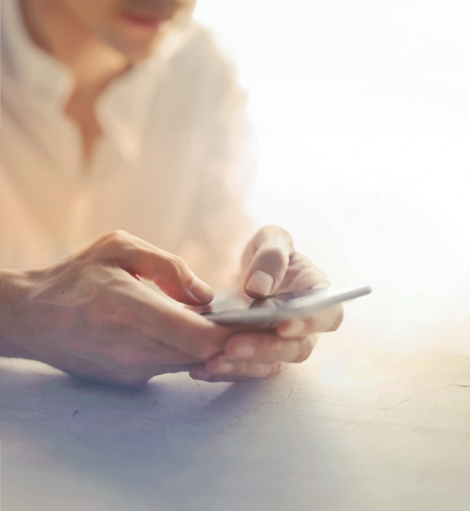 a person sitting at a table using a cell phone
