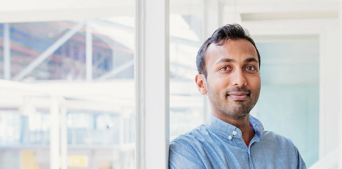 A picture of a smartly dressed man at the office, looking into the camera.